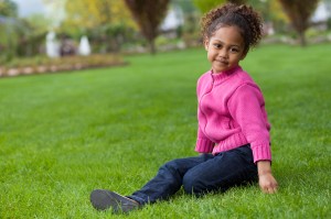 Little girl sitting on lawn