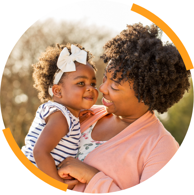 Mother smiling at her infant daughter outside