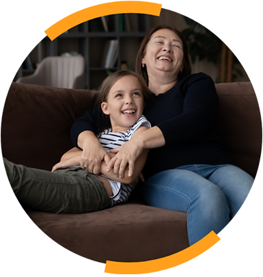 Woman and girl laughing on couch