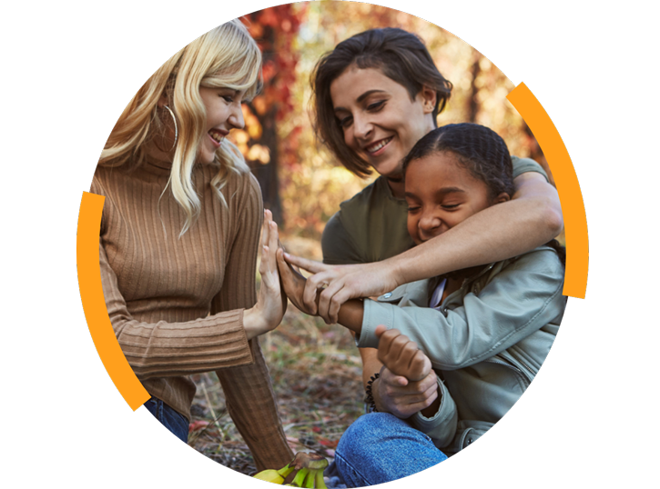 Two women outside with their daughter smiling