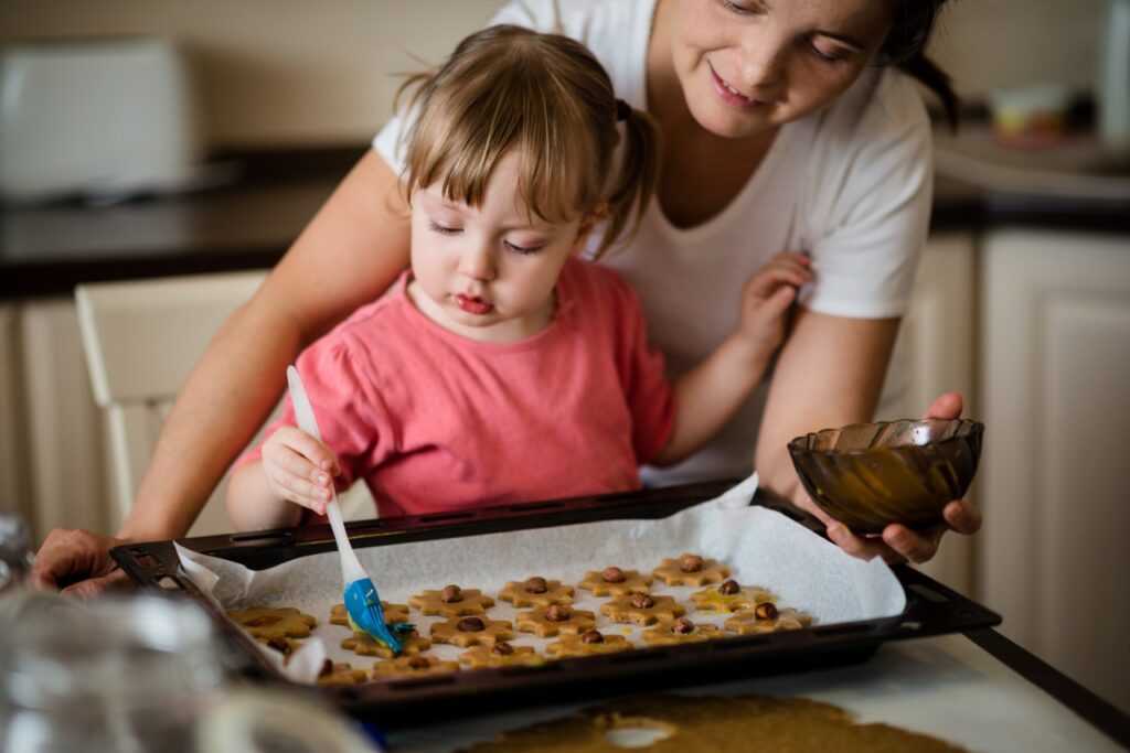 Young girl baking cookies with mother