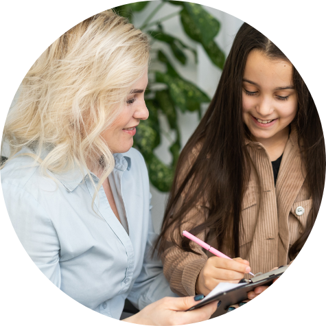 Woman and girl smiling down at clipboard