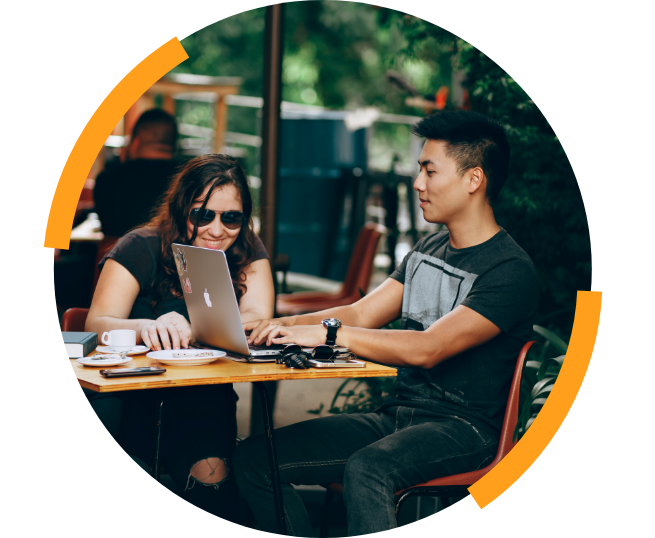 Teens smiling outside with laptop