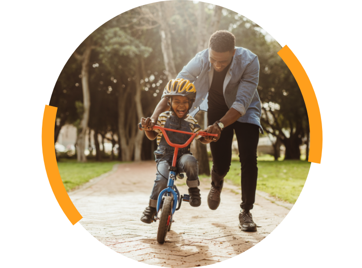 Boy riding a bike with father