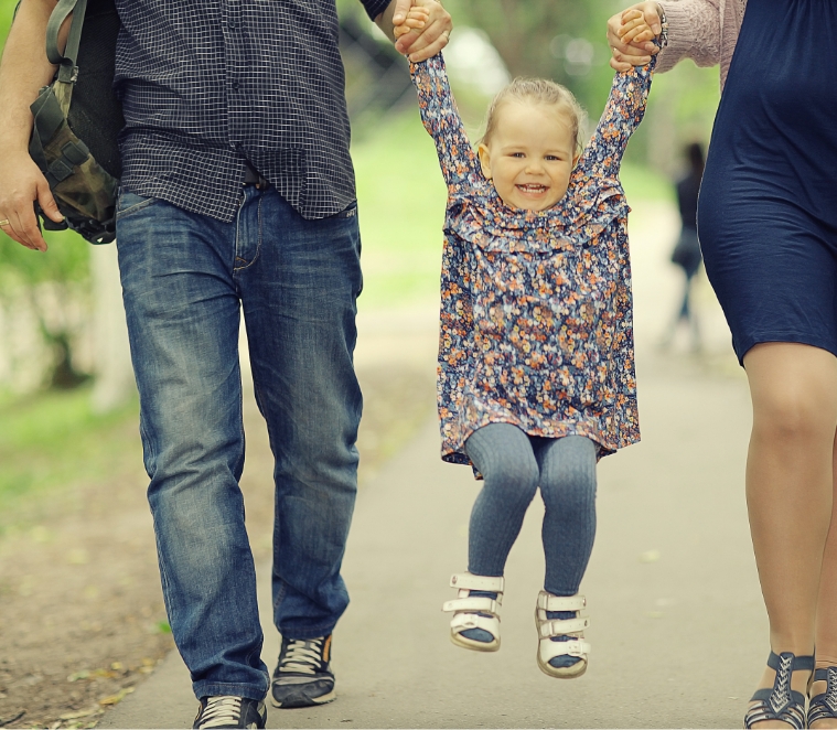 Young girl being lifted up by parents