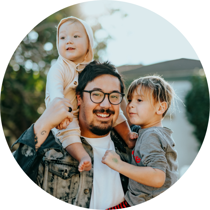 Father smiling with two young children