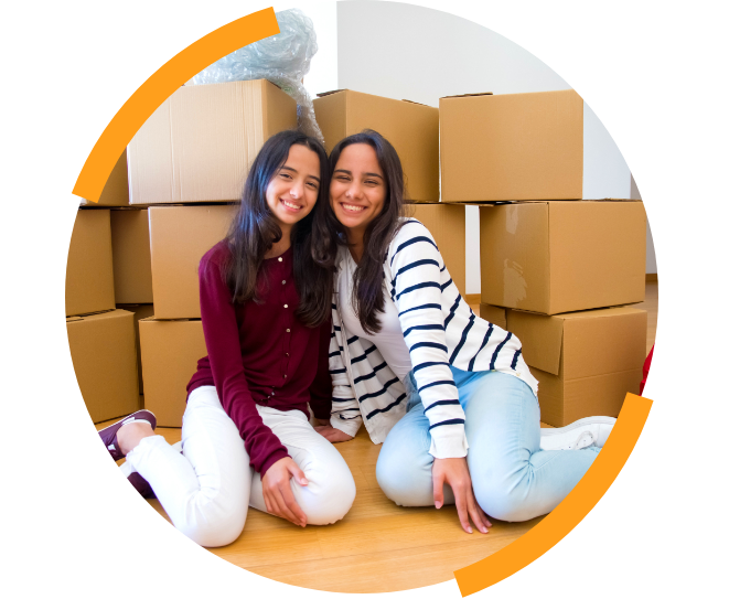Two teens in front of moving boxes smiling
